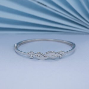 Polished silver bangle with entwined leaf and flower motifs, styled for Luxer